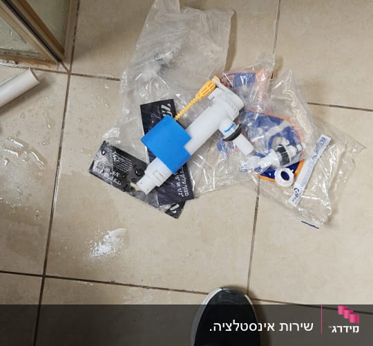 חלקי אינסטלציה על רצפת אריחים רטובה